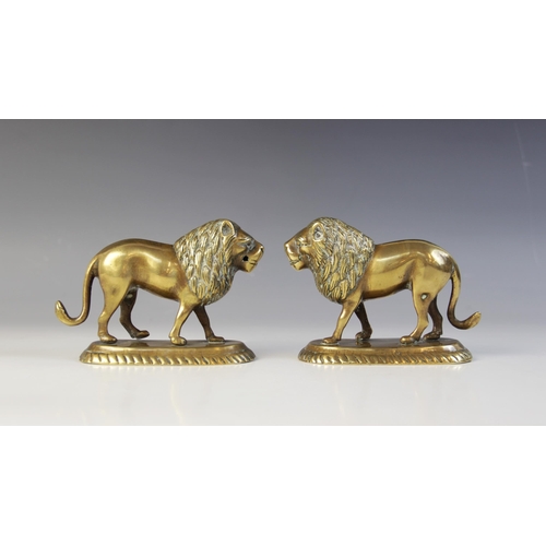 104 - A pair of Indian brass models of lions, late 19th/early 20th century, each modelled standing on an o... 