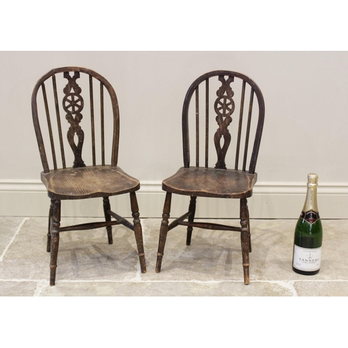 609 - A pair of child's elm seated wheel back kitchen chairs, mid 20th century, each with an arched back o... 