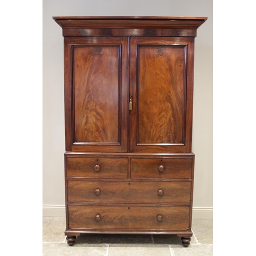 614 - A 19th century mahogany linen press, the cavetto cornice above a pair of invert panelled cupboard do... 