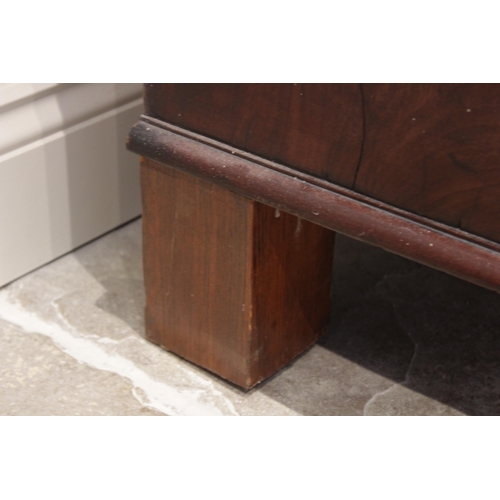 614 - A 19th century mahogany linen press, the cavetto cornice above a pair of invert panelled cupboard do... 