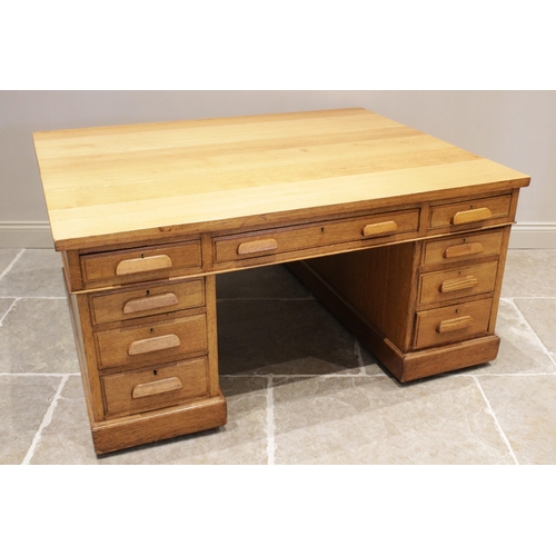 645 - A mid century golden oak partners desk, the rectangular slab top above three frieze drawers, upon tw... 