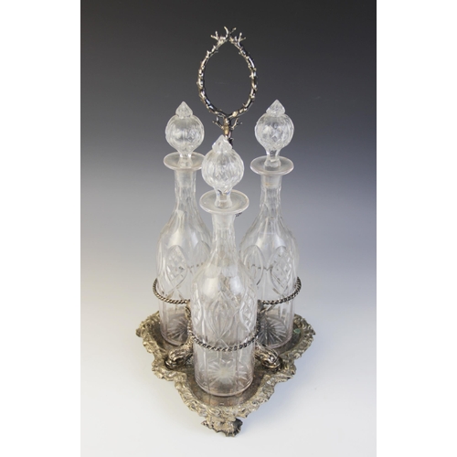 109 - A late 19th century silver plated triple decanter stand, trefoil base with cast rim and shell feet, ... 