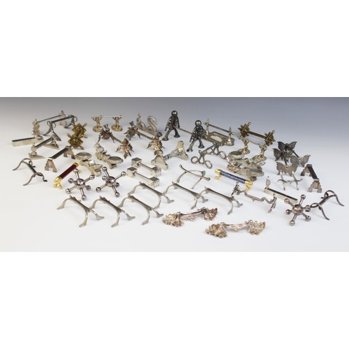 127 - A collection of 19th century and later novelty cutlery rests, including a pair of stylized thistle e... 