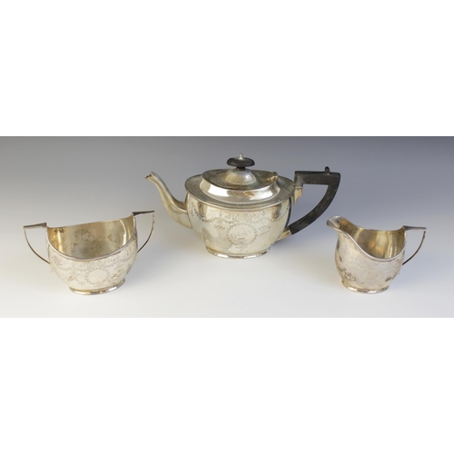 14 - An Edwardian silver tea service, Barker Brothers, Chester 1906, comprising teapot, sucrier and milk ... 