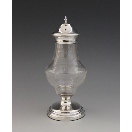 75 - A George V silver mounted glass sugar caster, of baluster form with floral swag decoration, weighted... 