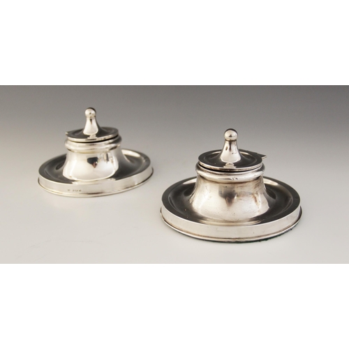 85 - A near pair of Edwardian silver mounted capstan inkwells, William Neale, Birmingham 1907, each with ... 