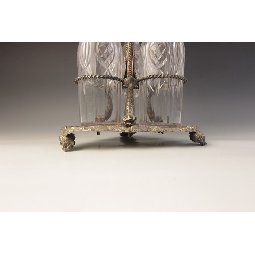 109 - A late 19th century silver plated triple decanter stand, trefoil base with cast rim and shell feet, ... 