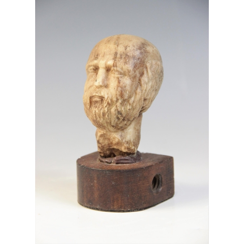 109 - A carved marble male head, 9cm high, upon a later wooden base, 12.5cm high overall (at fault)