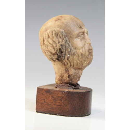 109 - A carved marble male head, 9cm high, upon a later wooden base, 12.5cm high overall (at fault)