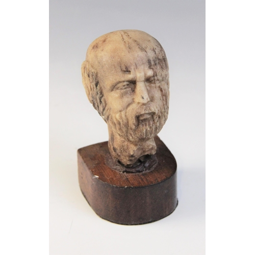 109 - A carved marble male head, 9cm high, upon a later wooden base, 12.5cm high overall (at fault)