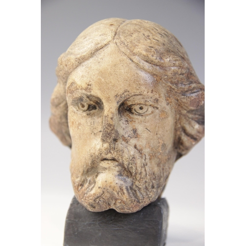 110 - A carved marble male head possibly Christ, modelled with detailed hair and beard, 11.5cm high, set t... 