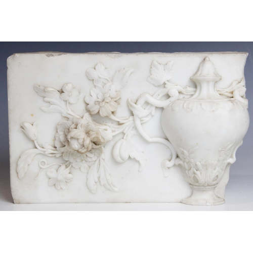 113 - A marble carving fragment, depicting a classical urn within a floral surround, 27.5cm W x 18cm L x 7... 