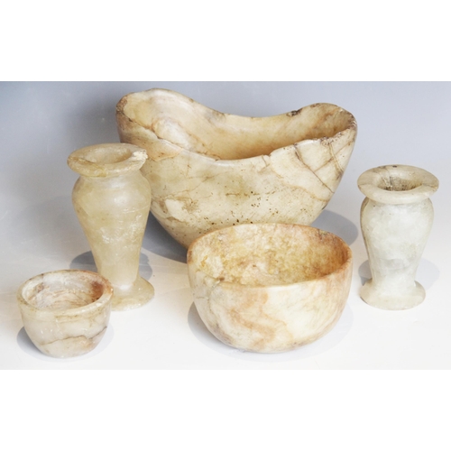 114 - A selection of carved alabaster vessels, to include a navette shaped vessel, 20.5cm wide, two vases ... 