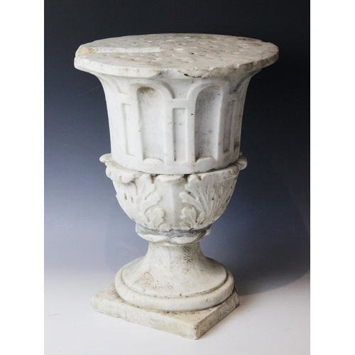 116 - A marble plinth, the urn base with relief carved acanthus leaves to body upon a stepped spreading fo... 