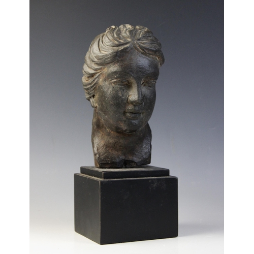 165 - A carved stone female head, the dark coloured stone carving (possibly originally part of a larger gr... 