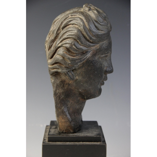 165 - A carved stone female head, the dark coloured stone carving (possibly originally part of a larger gr... 