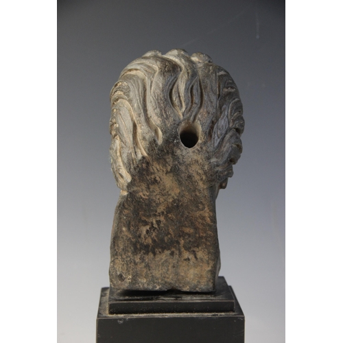 165 - A carved stone female head, the dark coloured stone carving (possibly originally part of a larger gr... 