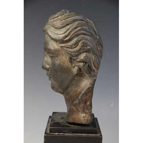 165 - A carved stone female head, the dark coloured stone carving (possibly originally part of a larger gr... 