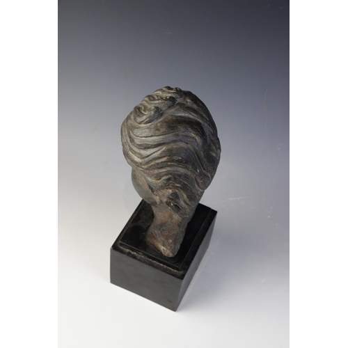 165 - A carved stone female head, the dark coloured stone carving (possibly originally part of a larger gr... 