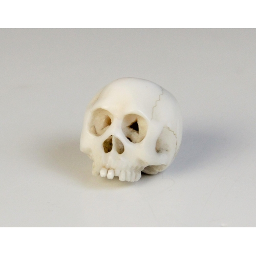 25 - * A 19th century carved ivory Memento Mori carving modelled as a skull, 2.5cm high (at fault)