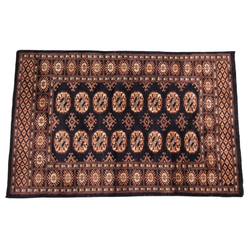 268 - * A small hand woven bokhara wool carpet, of typical design, with sixteen medallions against a dark ... 