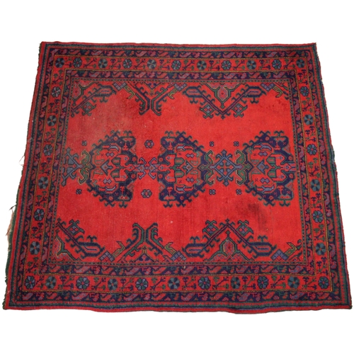 279 - A Turkish wool rug, in red, blue and green colourways, the three central medallions upon a vibrant r... 