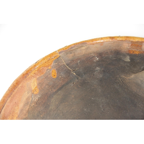 289 - A terracotta slipware footed dish, of circular form with three blade feet to base, the raised rim ab... 