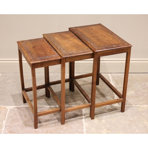 295 - * A nest of three Chinese carved teak tables, early 20th century, each carved with a border frieze o... 