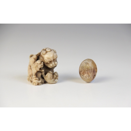 300 - * A Chinese carved stone model of a Dog of Fo, designed with two playful cubs, 3.5cm high, with a ca... 