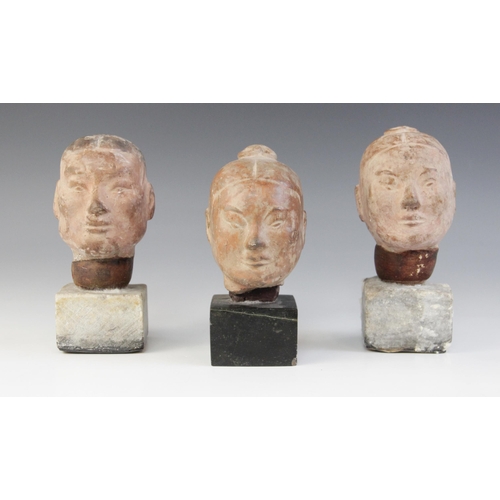 314 - Three Chinese terracotta heads, possibly Han dynasty, each buff glazed exterior with moulded feature... 