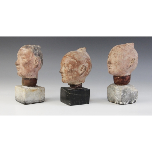 314 - Three Chinese terracotta heads, possibly Han dynasty, each buff glazed exterior with moulded feature... 