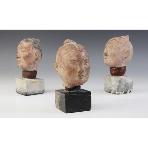 314 - Three Chinese terracotta heads, possibly Han dynasty, each buff glazed exterior with moulded feature... 