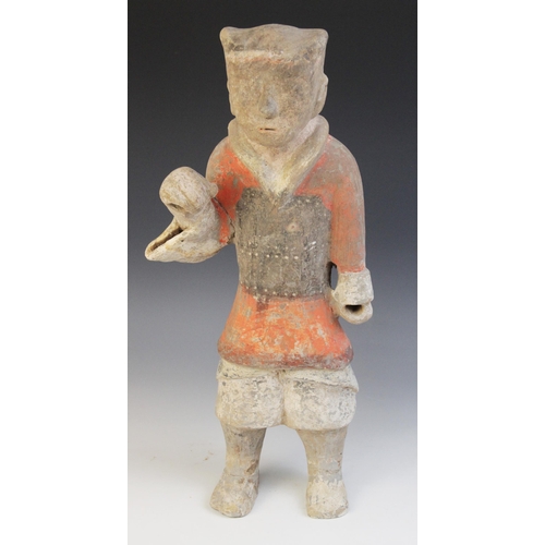 321 - A Chinese pottery warrior, possibly Han dynasty, modelled standing wearing armour and painted in bla... 