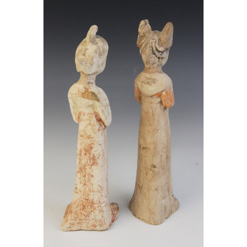 325 - Two Chinese pottery figures of female courtesans, possibly Sui/Tang dynasty, each modelled standing ... 