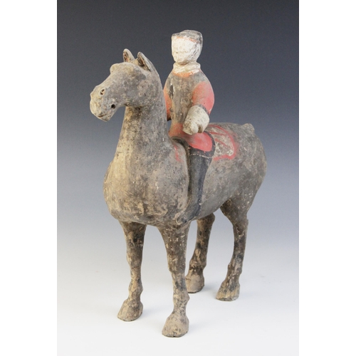 334 - A Chinese pottery model of a figure riding a horse, possibly Han dynasty, the horse standing on four... 