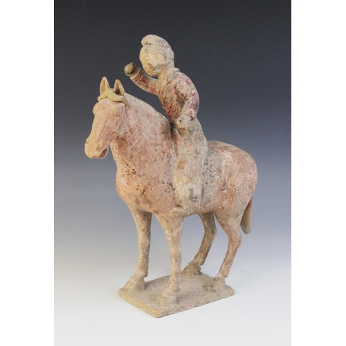 335 - A Chinese pottery model of a polo player on horseback, possibly Han dynasty, the horse raised on fou... 