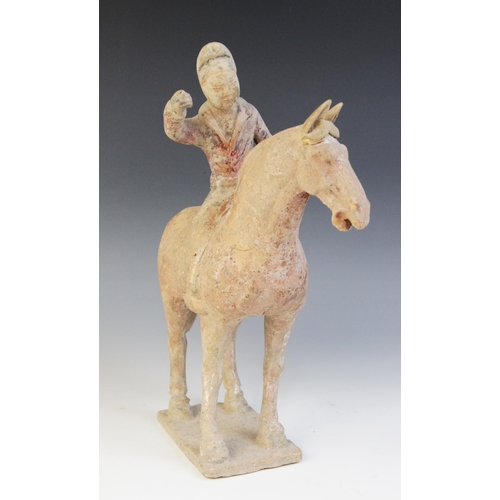 335 - A Chinese pottery model of a polo player on horseback, possibly Han dynasty, the horse raised on fou... 