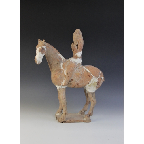 338 - A Chinese pottery model of a figure riding a horse, possibly Tang dynasty, the horse raised on four ... 