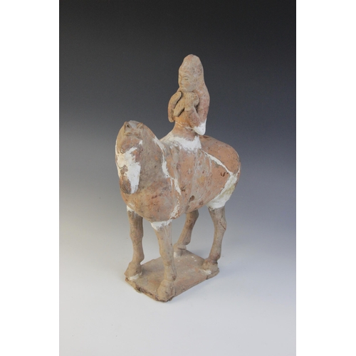 338 - A Chinese pottery model of a figure riding a horse, possibly Tang dynasty, the horse raised on four ... 