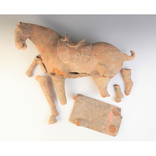 339 - A large Chinese pottery model of a horse, possibly Tang dynasty, modelled on four legs, and supporte... 