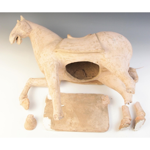 341 - A large Chinese pottery model of a horse, possibly Tang dynasty, modelled on four legs, with one rai... 