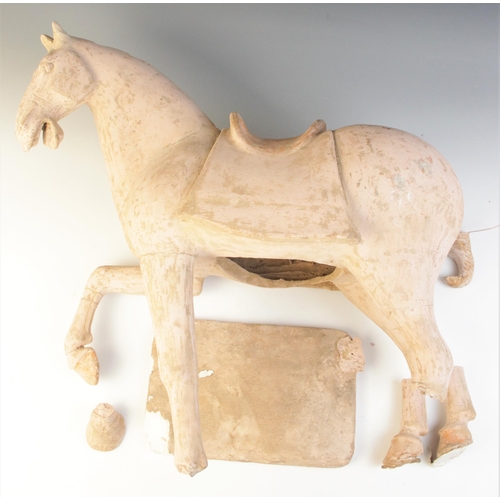 341 - A large Chinese pottery model of a horse, possibly Tang dynasty, modelled on four legs, with one rai... 