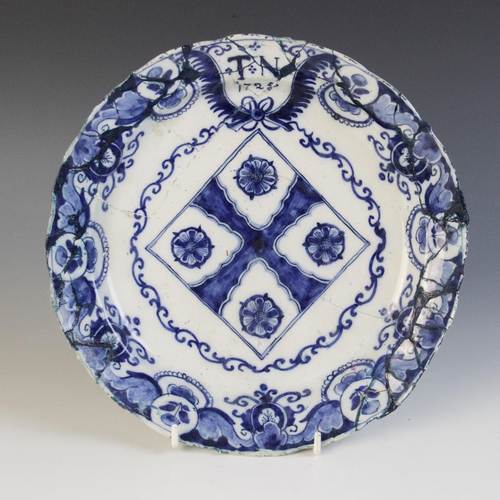 368 - A delft plate dated 1725, blue painted with a central lozenge with four stylised flower heads, initi... 