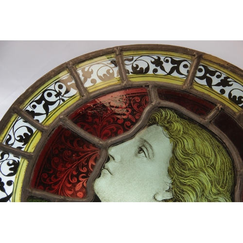 375 - An oval stained and painted glass portrait panel, 19th century, depicting a young gentleman in ornat... 