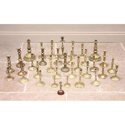 384 - A large collection of 18th century and later brass candlesticks, to include; continental and British... 