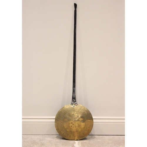 394 - A mid 17th century iron and brass warming pan, the tapering flat iron handle extending to a circular... 