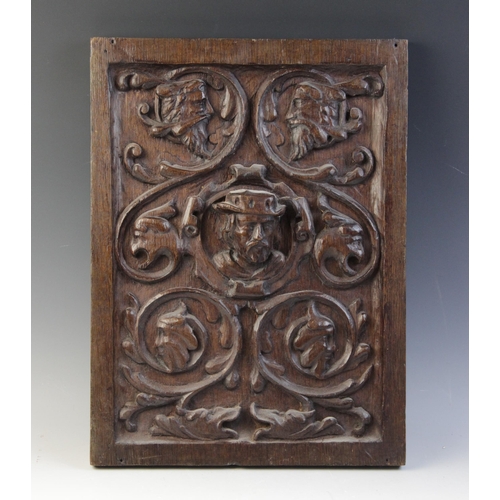 404 - A 16th century carved oak panel, designed as a male in high relief surrounded by scrolling foliage i... 