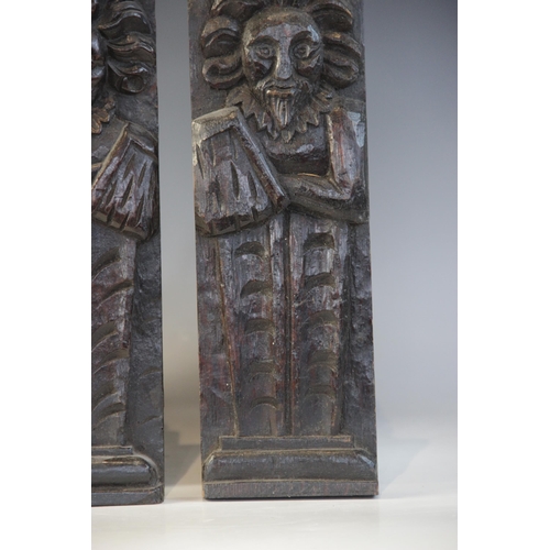 409 - A pair of late Elizabethan figural terms, each carved as a gentleman with his arm in a sling wearing... 