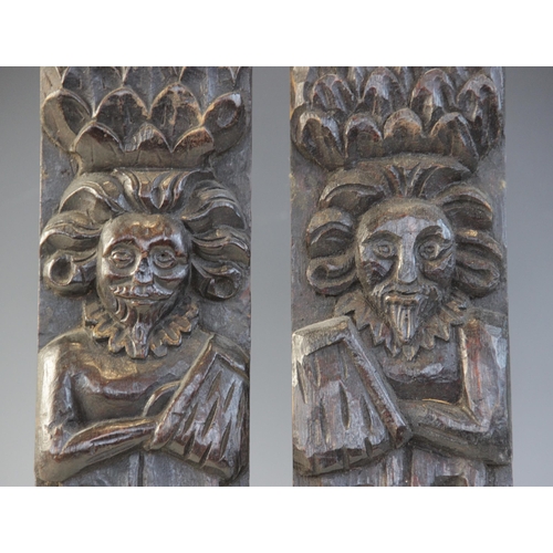 409 - A pair of late Elizabethan figural terms, each carved as a gentleman with his arm in a sling wearing... 