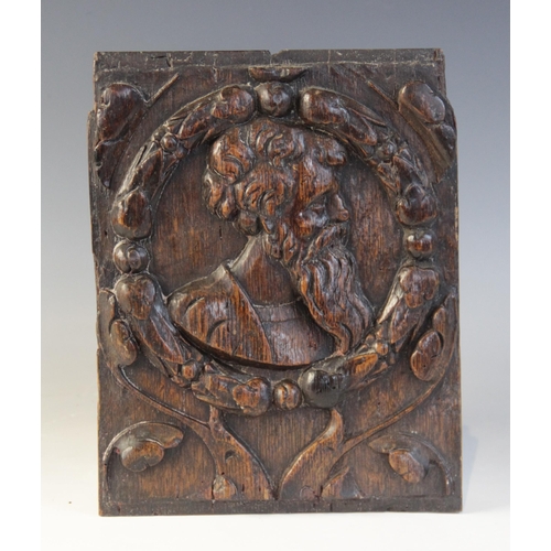 410 - A mid 16th century oak Romayne type carved oak panel, design with a bearded male within circular fol... 